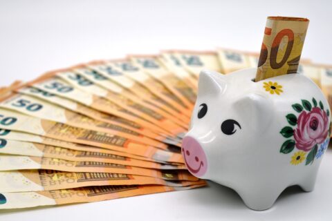 Tirelire à côté de billets de banque