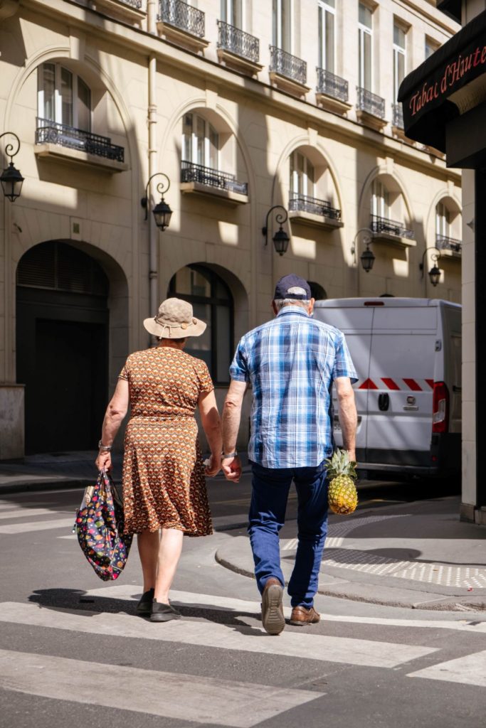Un couple de retraité marchant dans une rue de Paris