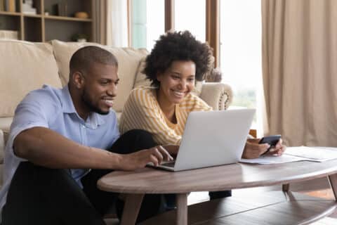 Jeune couple heureux utilisant un ordinateur portable