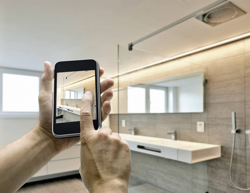 Smartphone avec homme mains prenant photo dans la salle de bains de luxe