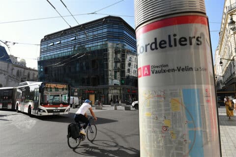 Cycliste et bus dans une rue de Lyon