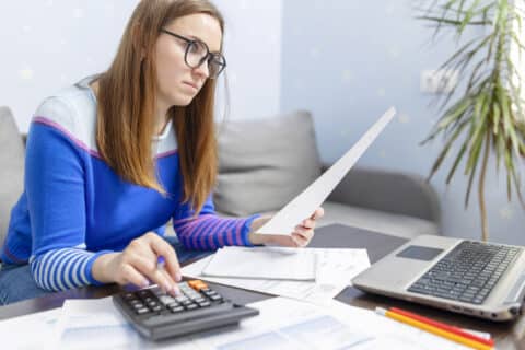 Femme utilisant une calculatrice pour payer les crédits