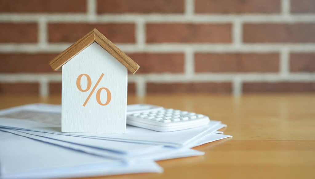 Maison et calculatrice représentant les taux d'intérêt d'un crédit