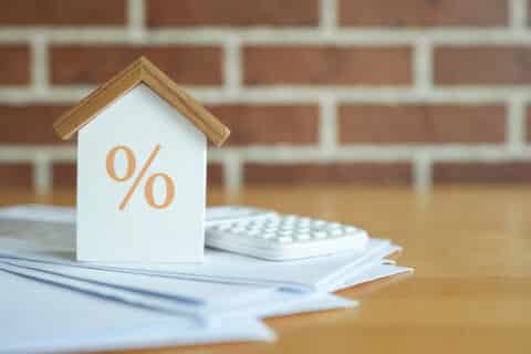 Maison et calculatrice représentant les taux d'intérêt d'un crédit