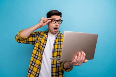 Photo d'un homme étonné fixant son ordinateur portable