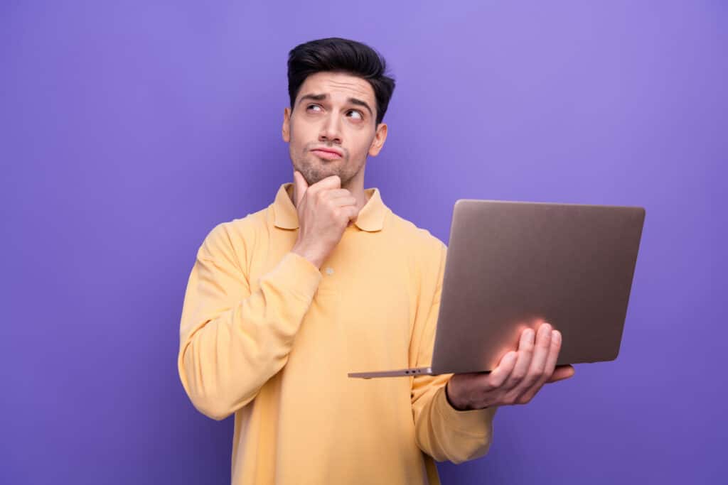 Photo d'un homme indécis portant son ordinateur portable