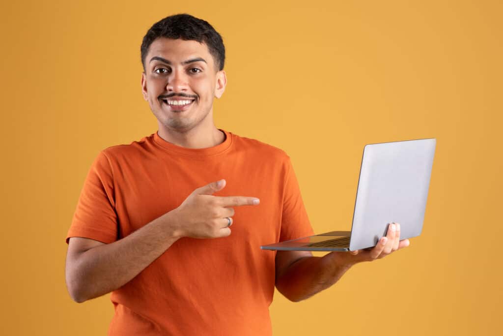 Homme content pointant vers l'écran de l'ordinateur portable