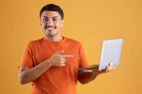 Homme content pointant vers l'écran de l'ordinateur portable