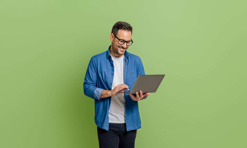 homme décontracté souriant analysant des données sur un ordinateur portable