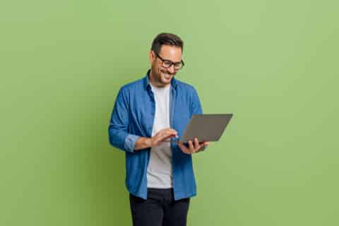 homme décontracté souriant analysant des données sur un ordinateur portable