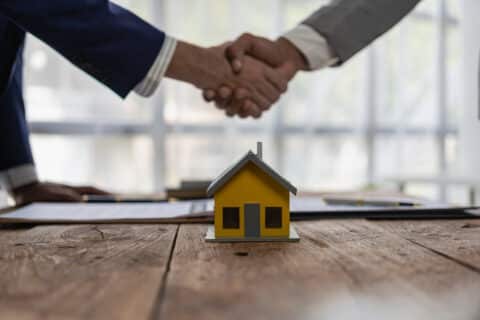 L'agent et le client se serrent la main après la signature du contrat d'achat d'une maison