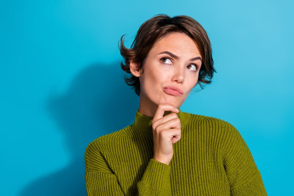 Femme indécise sur fond de couleur cyan