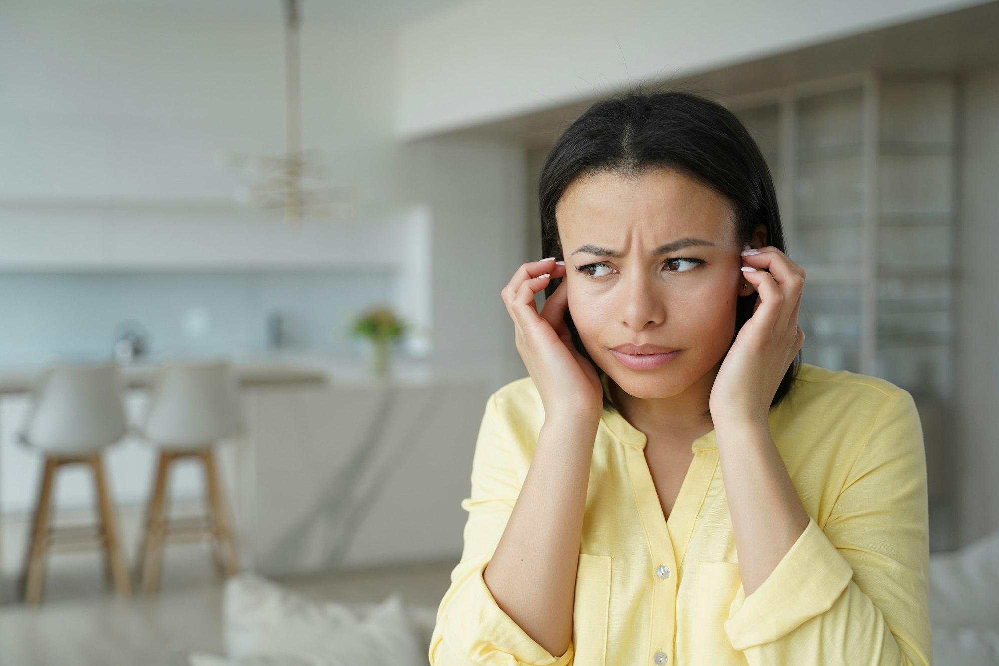 Girl is irritated with noise and closes her ears.  Conceptual portrait, advertising banner mockup. 