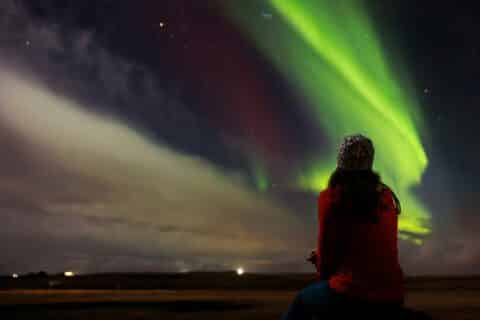 Tourist admiring magical aurora borealis