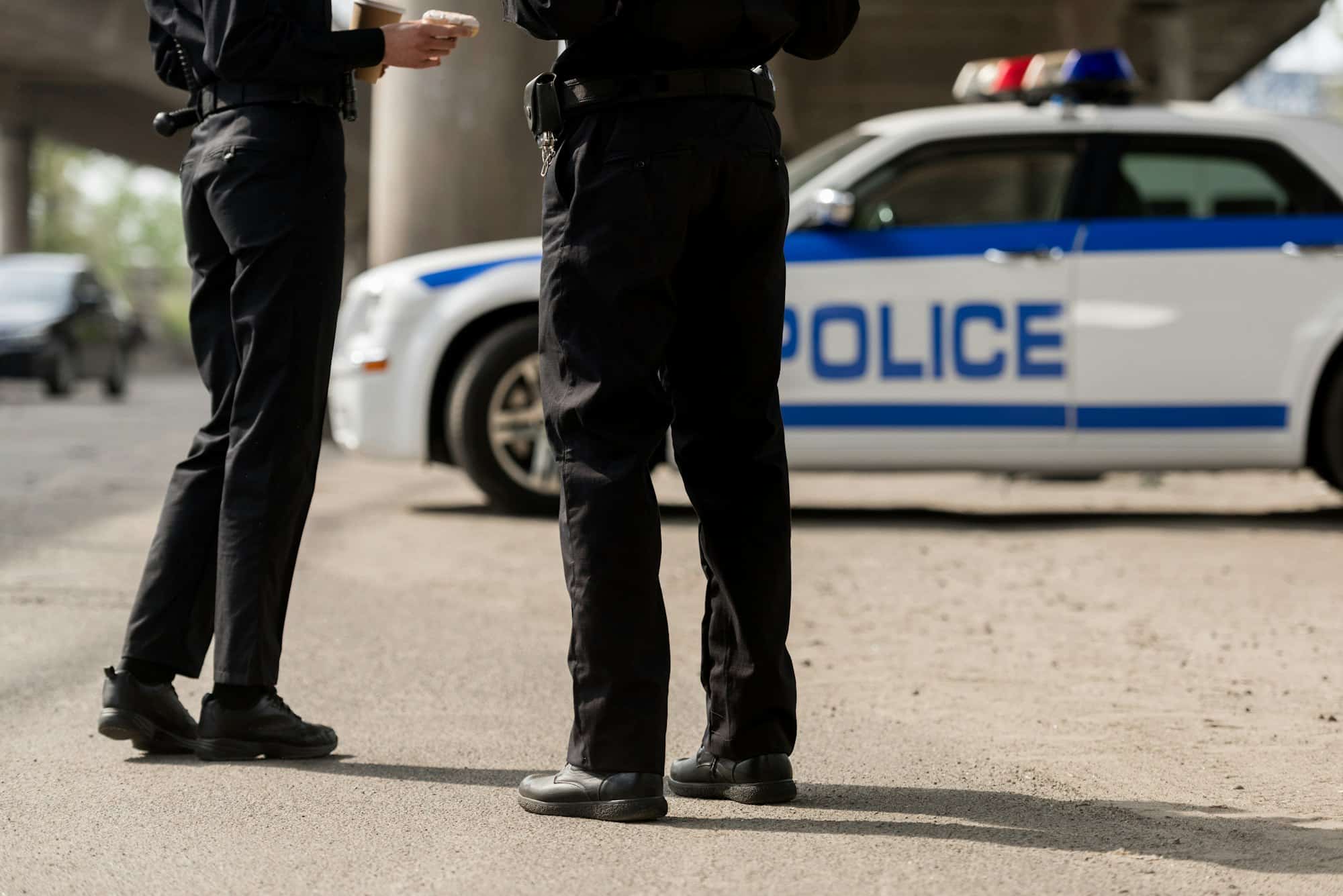 policiers debout devant une voiture de police