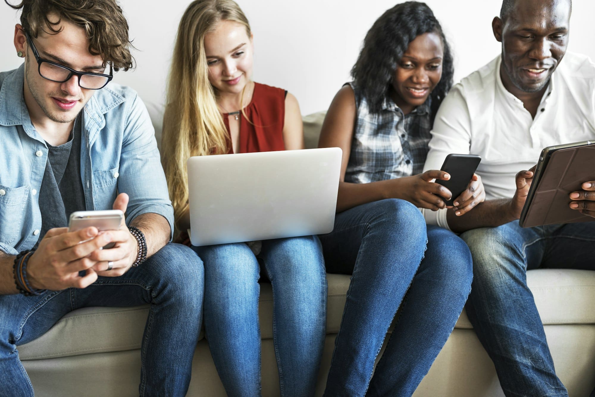 Groupe d'amis divers qui traînent et utilisent des appareils numériques