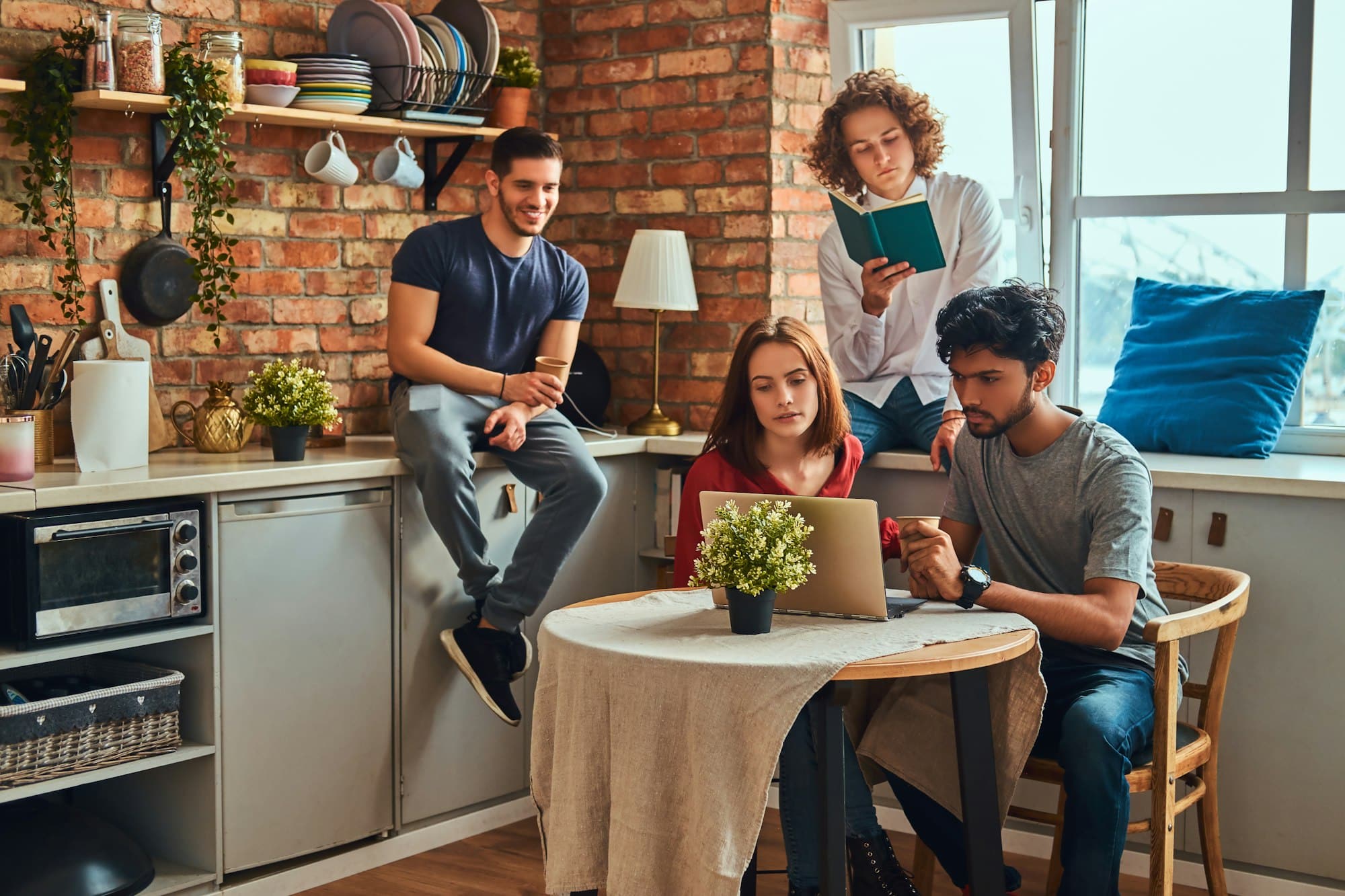 Kitchen in student dormitory. Group of interracial students engaged in education.