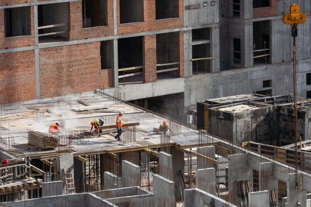 Construction worker Concrete pouring during commercial concreting floors of building in construction