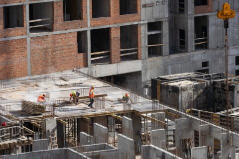 Construction worker Concrete pouring during commercial concreting floors of building in construction